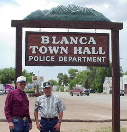 Two People Standing In Front Of the Town Hall Sign