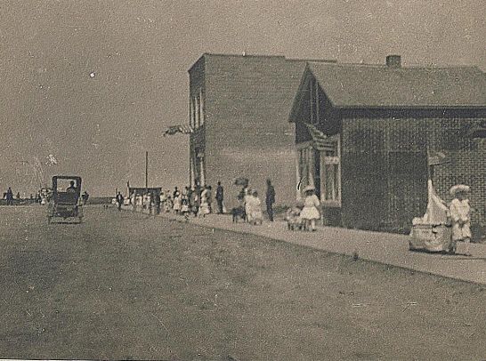 Children walking down a sidewalk as part of a parade